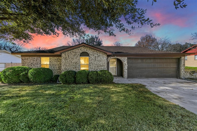 ranch-style home featuring a yard and a garage