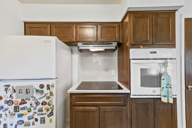 kitchen with white appliances and a textured ceiling