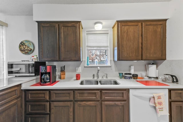 kitchen featuring dishwasher, a textured ceiling, a healthy amount of sunlight, and sink