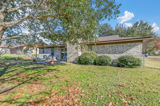 back of property with a yard and a patio