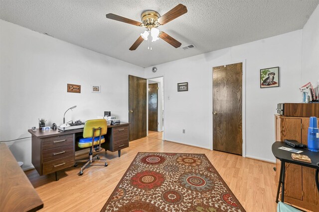 office featuring ceiling fan, light hardwood / wood-style floors, and a textured ceiling