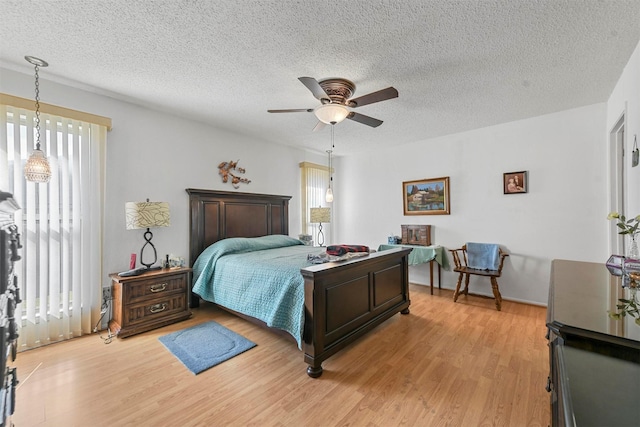 bedroom with multiple windows, ceiling fan, and light hardwood / wood-style floors