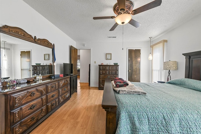 bedroom with multiple windows, a textured ceiling, light hardwood / wood-style flooring, and ceiling fan