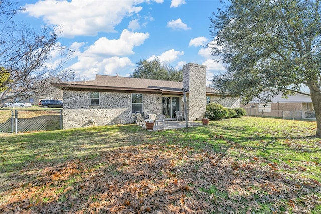 back of property featuring a lawn and a patio