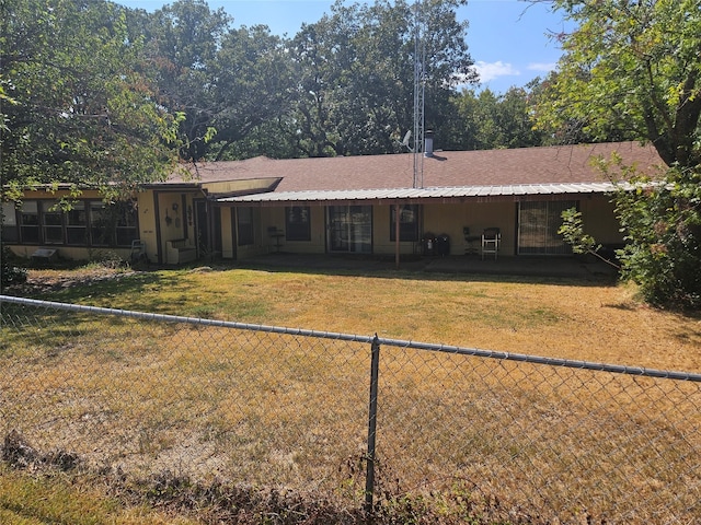 rear view of house featuring a yard