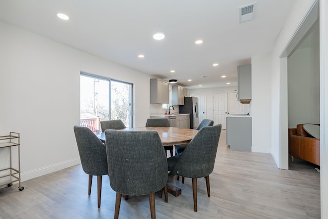 dining room with light hardwood / wood-style flooring and sink