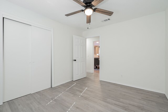 unfurnished bedroom featuring light wood-type flooring, a closet, and ceiling fan