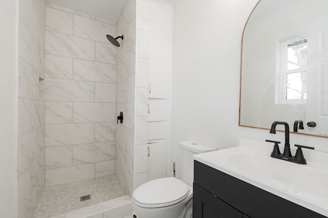 bathroom featuring vanity, toilet, and tiled shower