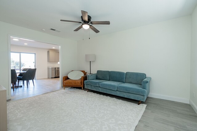 living room featuring ceiling fan and light hardwood / wood-style flooring