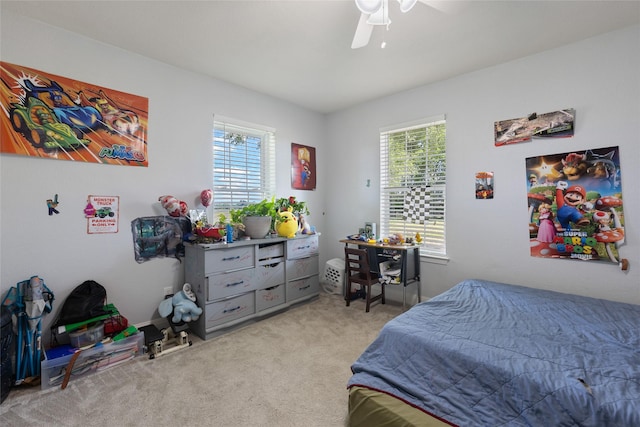 bedroom with multiple windows, ceiling fan, and light carpet