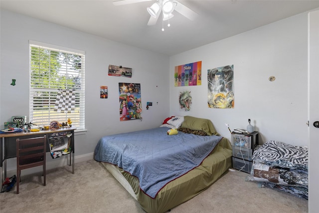 bedroom with ceiling fan, light colored carpet, and multiple windows