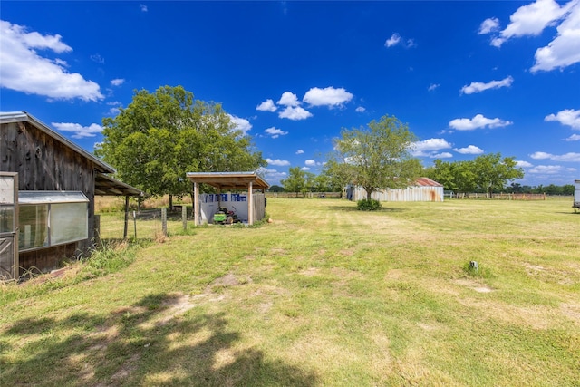 view of yard with an outbuilding and a rural view