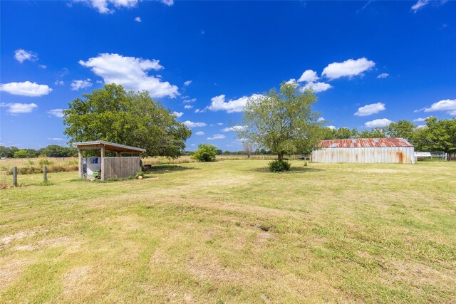 view of yard featuring an outbuilding and a rural view