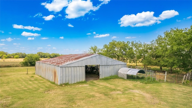 view of outdoor structure featuring a lawn and a rural view