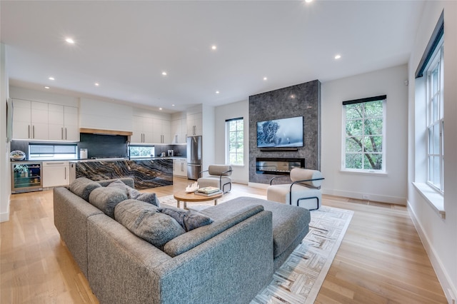 living room with light hardwood / wood-style floors, a fireplace, and wine cooler