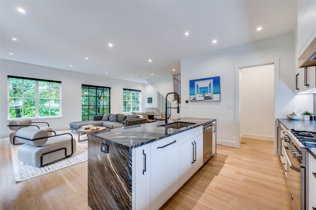 kitchen with white cabinets, light wood-type flooring, and sink