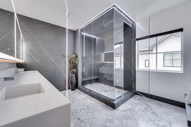 bathroom featuring a shower with door and vanity