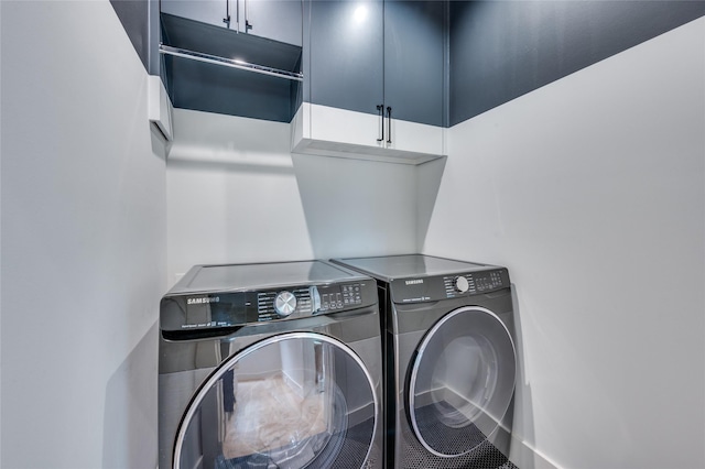 washroom featuring washer and dryer and cabinets