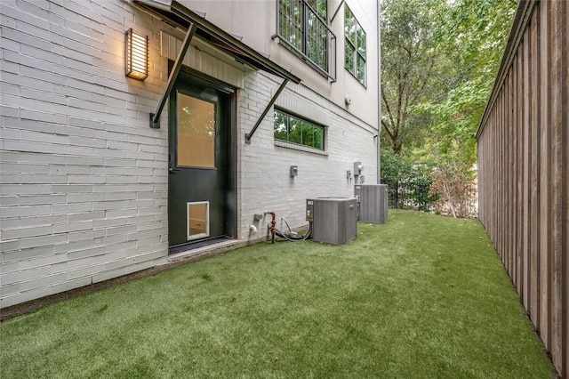 view of side of property with a lawn and cooling unit