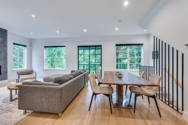 dining area featuring a tiled fireplace and light hardwood / wood-style flooring