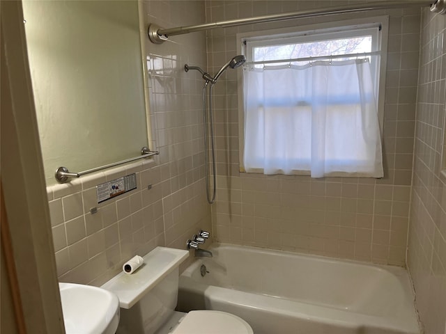 bathroom with tile walls, tiled shower / bath combo, and toilet