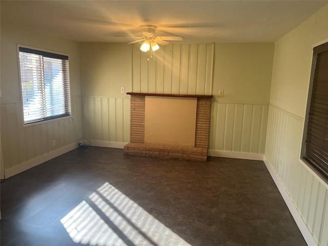 unfurnished living room featuring ceiling fan and a fireplace