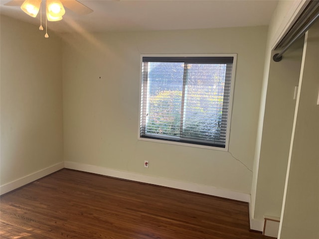 empty room with dark hardwood / wood-style floors and ceiling fan