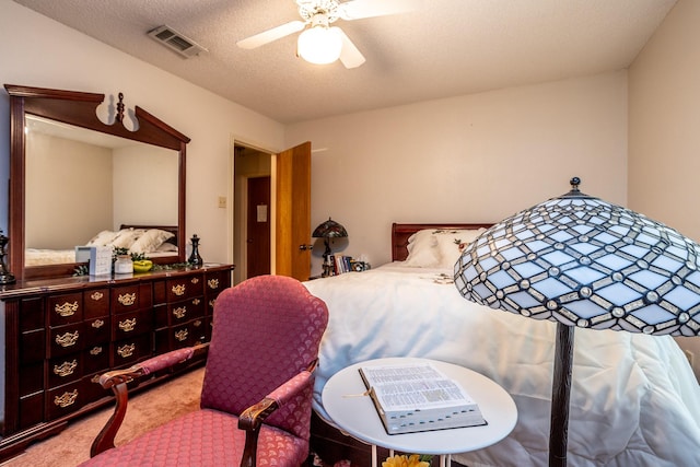 carpeted bedroom with ceiling fan and a textured ceiling