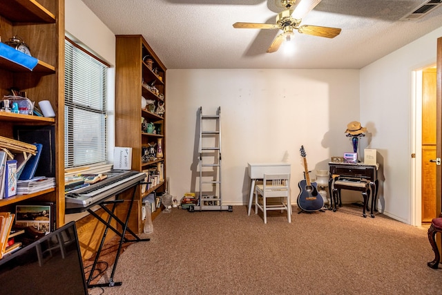 misc room with ceiling fan, carpet floors, and a textured ceiling