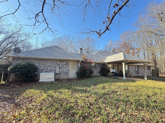 rear view of house featuring a yard and a patio