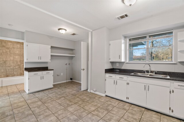 kitchen featuring white cabinets, light tile patterned floors, and sink