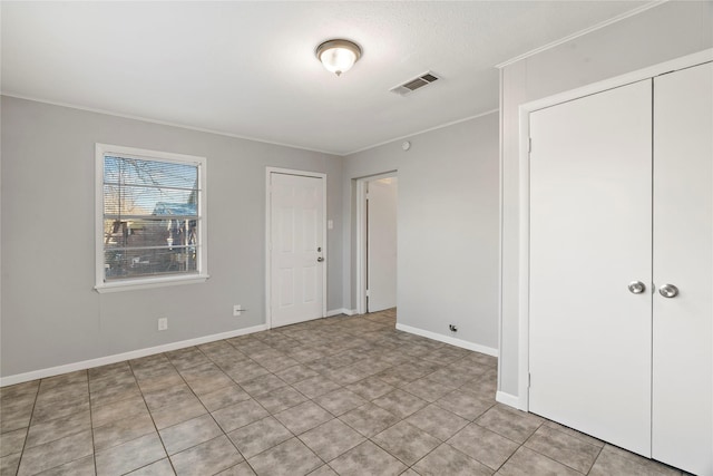 unfurnished bedroom with baseboards, visible vents, and crown molding