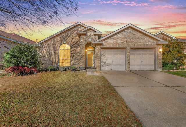 view of front of property with a garage and a lawn