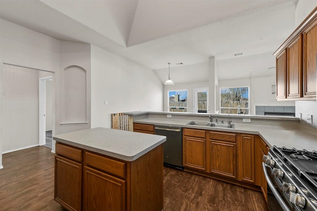 kitchen featuring sink, dark wood-type flooring, pendant lighting, vaulted ceiling, and appliances with stainless steel finishes