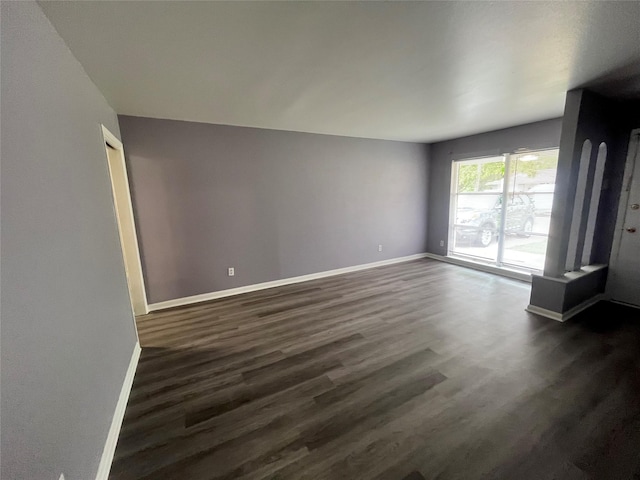 unfurnished living room with dark wood-type flooring