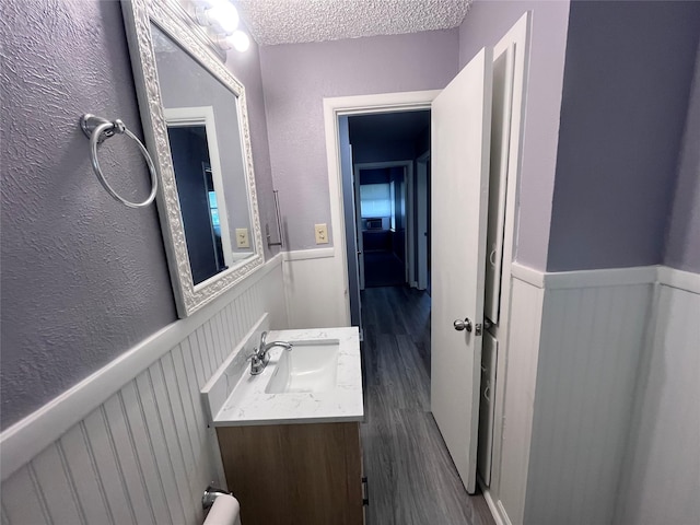 bathroom with vanity, a textured ceiling, and hardwood / wood-style flooring