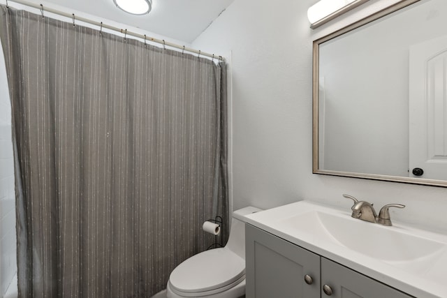 bathroom featuring vanity, toilet, and curtained shower