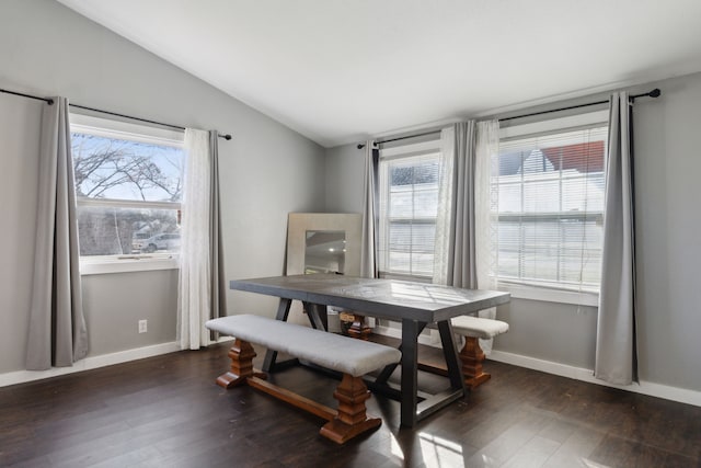 dining area featuring dark wood-type flooring and vaulted ceiling