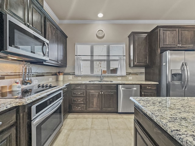 kitchen with appliances with stainless steel finishes, light stone counters, dark brown cabinetry, crown molding, and sink