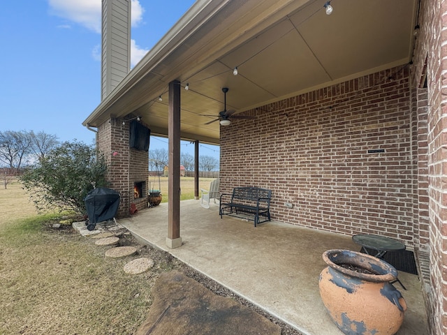 view of patio / terrace featuring area for grilling, an outdoor brick fireplace, and ceiling fan