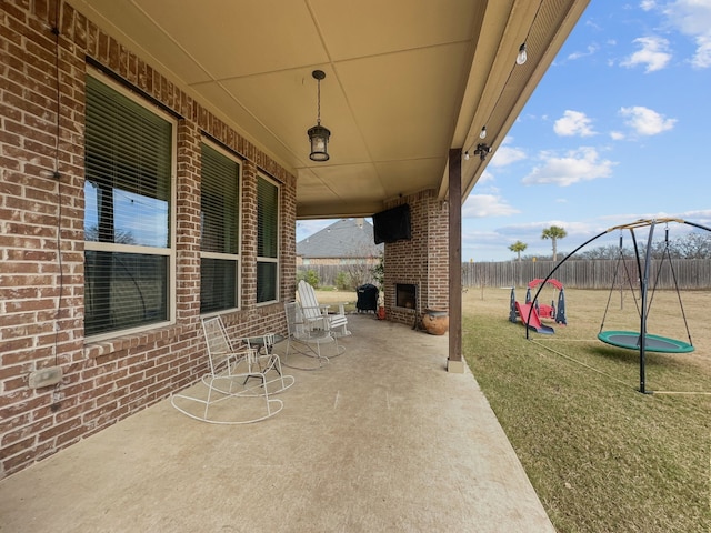 view of patio / terrace with a playground and an outdoor brick fireplace