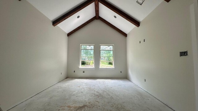 spare room with beam ceiling and high vaulted ceiling