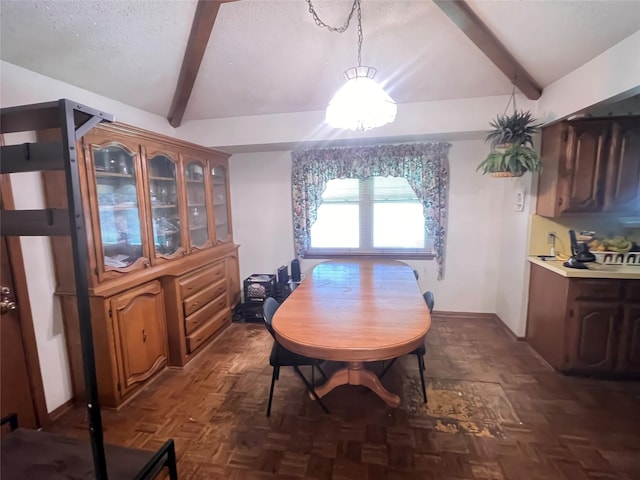 dining area with dark parquet flooring, lofted ceiling with beams, and a textured ceiling