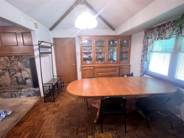 dining space featuring lofted ceiling and dark parquet floors