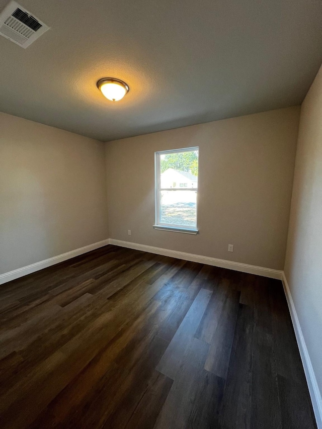 spare room with dark hardwood / wood-style floors