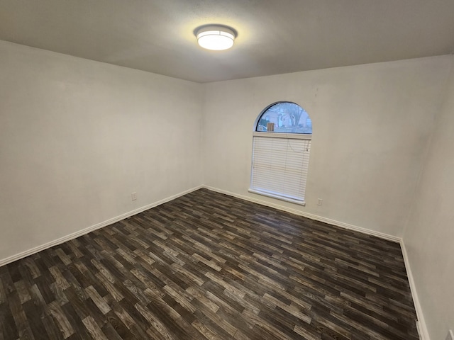 unfurnished room with dark hardwood / wood-style flooring