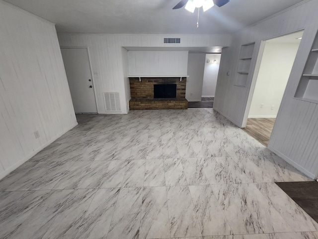 unfurnished living room with built in shelves, a fireplace, and ceiling fan