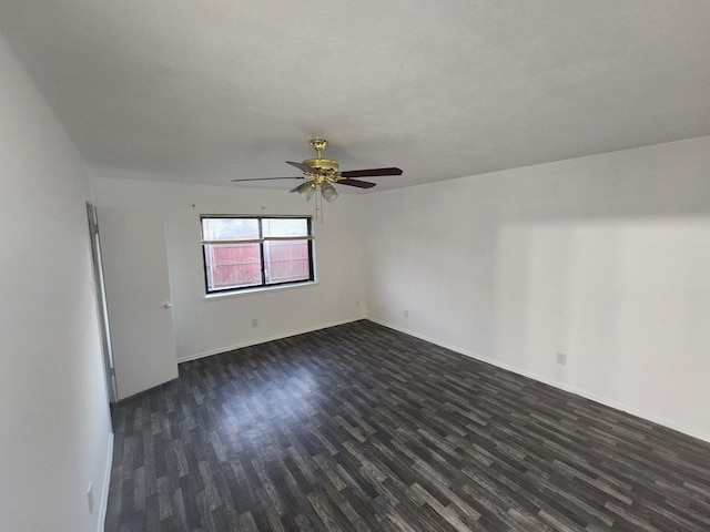 spare room featuring ceiling fan and dark wood-type flooring