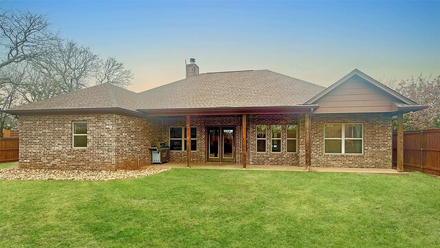 1505 Cross Oaks Ct, Graham, TX 76450 - back of house featuring brick siding, a chimney, roof with shingles, and a patio area