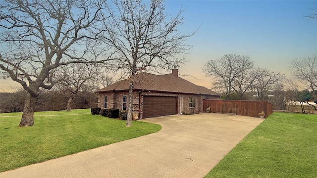 property exterior at dusk with a garage and a yard